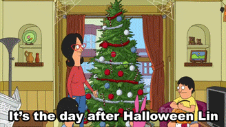 A GIF in which a woman admires a Christmas tree, the picture zooms out and shows her husband who says "It's the day after Halloween, Lin"