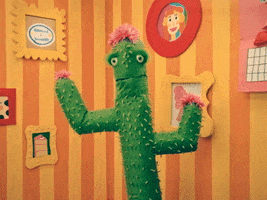 TV gif. A green cactus puppet in Happy Place with pink flowers on its head and arms stands up in a bright cartoonish living space as it says, "You have my whole heart."