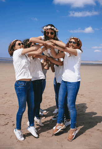 Gif s dívkami slavícími rozlučku se svobodou na pláži, vyhazující nevěstu do vzduchu. 