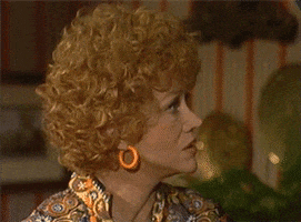 TV gif. Audra Lindley as Helen Roper on Three’s company slowly turns her head as she processes what she just heard. She wrinkles her nose and then her eyes open wide as she realizes.