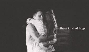 Video gif. A black-and-white scene of a man and a woman hugging tenderly. The woman runs her hand through the man's hair. Text, "These kind of hugs [sic]."