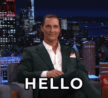 Tonight Show gif. Matthew McConaughey sits for an interview, doing finger guns, smiling and saluting the audience saying, "Hello."