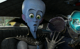 Movie gif. Megamind reaches a window and smashes his face against the glass, looking amazed.