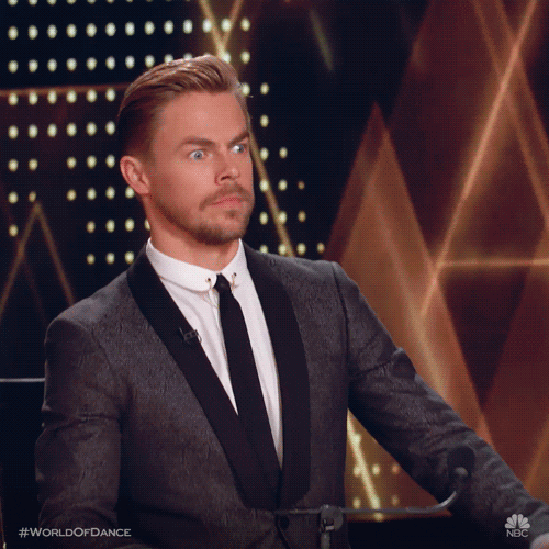 Reality TV gif. Derek Hough from World of Dance freezes and gazes ahead with raised eyebrows like he's in shock and awe. 