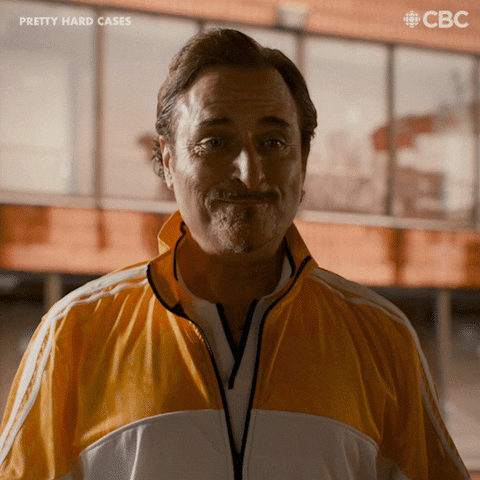 TV gif. From Pretty Hard Cases, a man in a yellow tracksuit shrugs and says happily, “It’s Friday!”