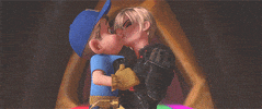 Movie gif. In a scene from Wreck-It Ralph, Fix-It Felix Jr. looks surprised as he kisses Sergeant Calhoun, looking at her and then closing his eyes to caress her cheek. Red hearts pop up all around them. 