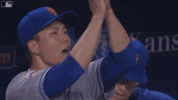 Sports gif. Kodai Senga of the New York Mets gives an energetic high clap above his head and nods approvingly from the dugout. 
