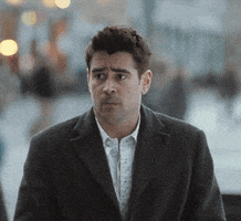 Movie gif. Colin Farrell wears an oversized jacket on a busy street. He shrugs his shoulders and has an exaggerated frown on his face like he has no clue what's going on. 