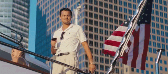 Lenodardo DiCaprio na lodi ve filmu Velký Gatsby pozvedající číši s červeným vínem.