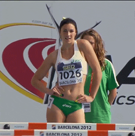 Sports gif. Vivacious track star Michelle Jenneke swings her hips, bouncing sexily as she prepares for a race.