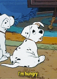 Movie gif. Rolly, a puppy from the classic animated 101 Dalmatians movie has its chubby puppy body back turned to us. He looks over his shoulder with big, sad eyes, and a droopy face and says, “I'm hungry.”