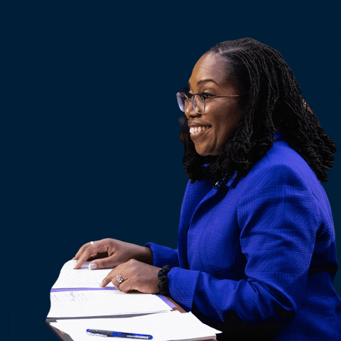 Political gif. Profile of Ketanji Brown Jackson against a navy blue background as she smiles behind a desk scattered with papers. Quoted text, "I am an independent jurist. I am impartial."