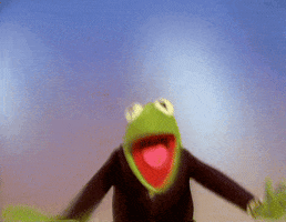 Muppets gif. Kermit the Frog is waving his arms excitedly in the air while jumping goofily and he gives us an open-mouthed grin. 