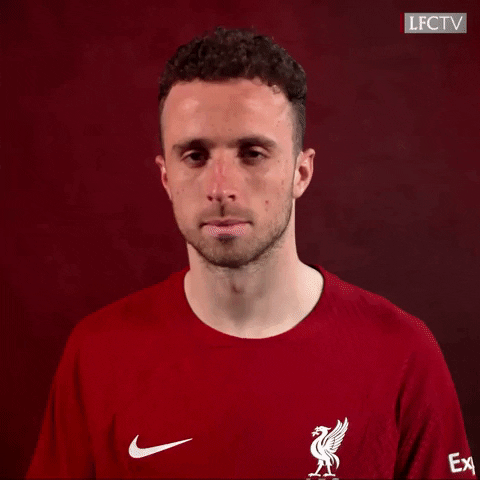 Video gif. Portuguese soccer player Diogo Jota looks at us and beckons us to come closer as the camera pans in, and he tosses it away to a black screen. 