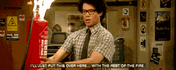 TV gif. Richard Ayoade as Moss from The IT Crowd awkwardly holds a fire extinguisher that's...on fire. Text, "I'll just put this over here...with the rest of the fire."
