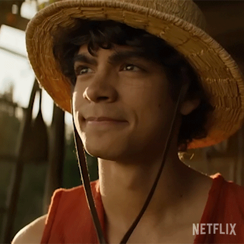 TV or movie gif. Masataka Kubota as Roronoa Zoro from "One Piece" wearing a straw hat and red tank top, looks up and away with a determined and confident expression.