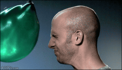 slow motion gif of a water balloon exploding in a man's face