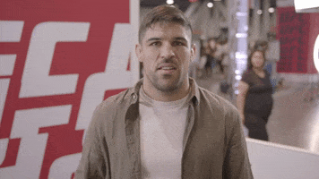 Sports gif. Vicente Luque pumps his fist as he says, "Yes."