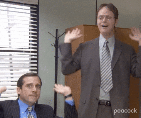 Gif se dvěma muži v oblecích vztahující obě ruce ke stropu na znamení oslavy.