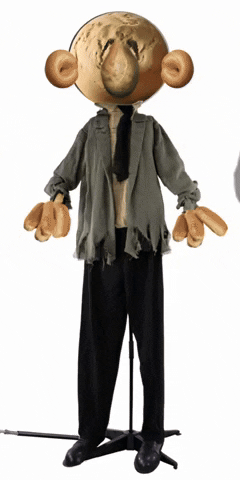 Video gif. A zombie-like figure morphed out of bread-colored clay moves its head and arms while standing in place. 
