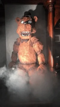 GIF of animatronic giant teddy bear moving in smoke.