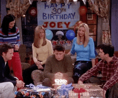 Friends gif. Joey, flaming birthday cake in front of him and Happy 30th Birthday banner above him, wails to the heavens "WHY GOD WHY."