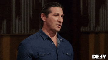 Reality TV gif. Wil Willis as host of Forged in Fire smiles and glances around as he says, "Welcome back to the Forge."