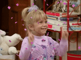 TV gif. Mary Kate or Ashley Olsen as Michelle Tanner in Full House smiling and dancing by pointing her fingers up in the air. Animated pink confetti rains down, and text pops up saying "fun!"