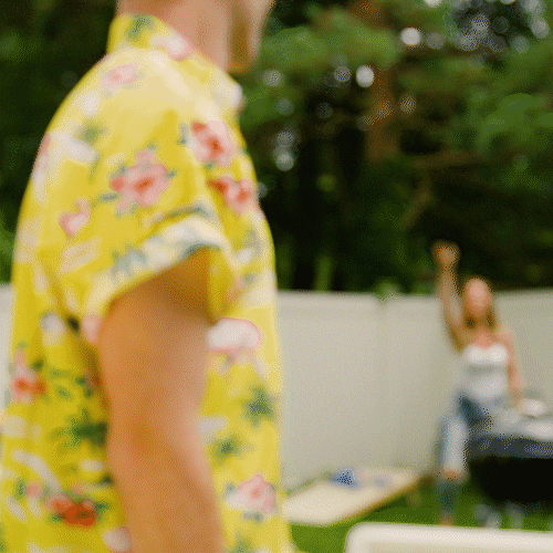 Ad gif. A celebrating man in a yellow hawaiian shirt raises a hand with a yellow can in it. Blue text reads, "Twisted Tea."