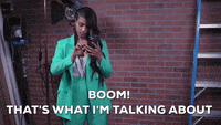 TV gif. Lilly Singh as host of A Little Late looks down at her green suit, shakes out her arms and says, 