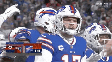 Sports gif. Buffalo Bills quarterback Josh Allen walks through his team, who pat him on the back, and yells, “Let’s go!”