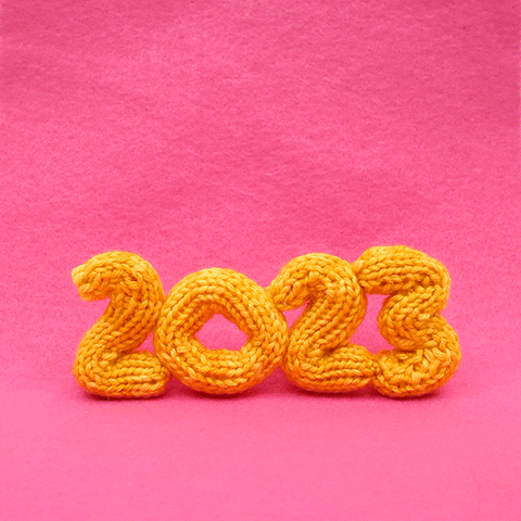 3D animated gif. Several white knitted rabbits wearing red and white sweaters jump in unison across yellow knit letters spelling "2023" against a hot pink background. One rabbit hops back across the frame in the other direction like, "Let's do that again!'