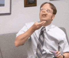 The Office gif. Rainn Wilson as Dwight wears a fake pig snout. He chomps down as he shovels food into his mouth.