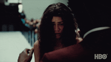TV gif. Zendaya as Rue from Euphoria. She's sobbing and looks wrecked. Someone approaches her and wraps her in a hug and her head folds into their shoulder.