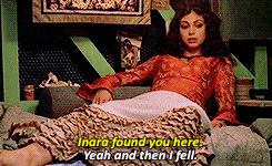 TV gif. Morena Baccarin as Inara in Firefly lounges in an opulent dress as she points and looks up while saying, "Inara found you here. Yeah, and then I fell."