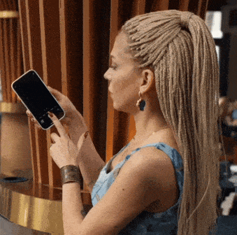 Person lifting a phone to photograph what is in front of them instead of typing