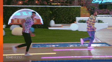 Reality TV gif. Two men on Love Island run together like they’re running away from something.