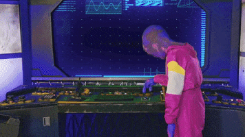 Video gif. In a spaceship, a person dressed as a purple alien pushes some buttons on the ship's dashboard. A message appears on the ship's screen: "Boo!" The alien falls away and clutches its chest, frightened, before taking some deep breaths and recovering from the jump scare.
