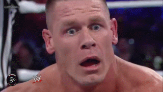 Sports gif. John Cena in a WWE match looks down with wide eyes and a face full of confusion. He furrows his brows as he tries to process what just happened.