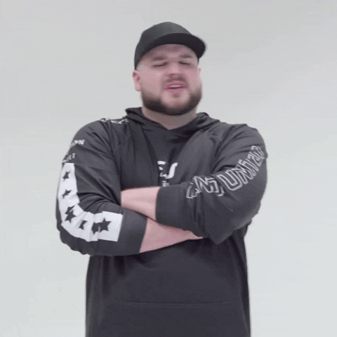 Video game gif. Legiqn, a streamer from eUnited, a gaming organization. We slowly zoom in on him as he stands with his arms crossed, shaking his head. He looks unhappy and disappointed, as if something could've gone better.