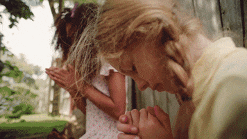 Music video gif. Young girls are closing their eyes and putting their hands up in prayer and the shot cuts to Chrissy Metz singing, who also puts her hands up in prayer. 