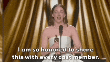 Oscars 2024 GIF. Emma Stone wins Best Actress. She clutches the trophy with both of her hands and uses it to punctuate her statement, which reads, "I am so honored to share this with every cast member."