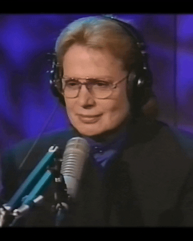 Celebrity gif. Sitting in a studio with headphones on, Walter Mercado nods in agreement.