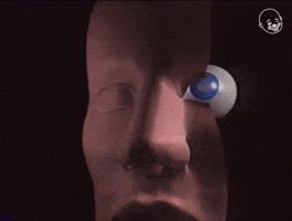 Digital art gif. A 3D video of a face that is split in half to reveal the eye in its socket. It zooms in on the eye and the eye also gets cut in half, so we're able to see the inside of the eyeball and what it's made of.