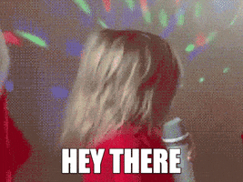 Celebrity gif. Audrey Nethery, a young girl with blonde hair, faces away from us holding a silver microphone. She whips her head around, dramatically pushing her long hair off her face and making a sensual expression.