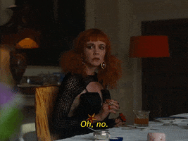 Movie gif. Carey Mulligan as Pamela in Saltburn. She sits at a dining table with a furrowed brow and a shocked expression on her face as she fidgets her hands and says, “Oh no.”
