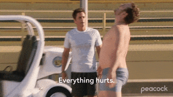 Parks and Recreation gif. Rob Lowe as Chris looks on as an exhausted, shirtless Chris Pratt as Andy Dwyer lies down on a running track. Text, "Everything hurts. Running is impossible."