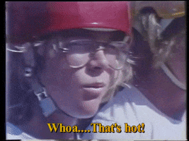 Video gif. A boy wearing a red helmet and 1980s glasses slowly turns to face us. He smirks, impressed and says, “Whoa…That’s hot!”