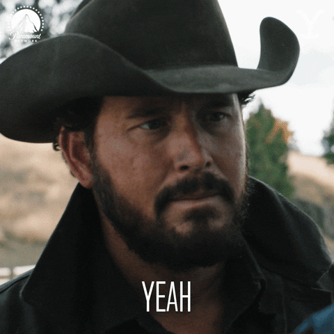TV gif. Wearing a dark cowboy hat, Cole Houser as Rip on Yellowstone quickly glances down and up and says "yeah," which appears as text.