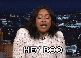 Tonight show gif. A woman jauntily throws up a peace sign, rocking her shoulders back slightly. Text. "Hey boo"